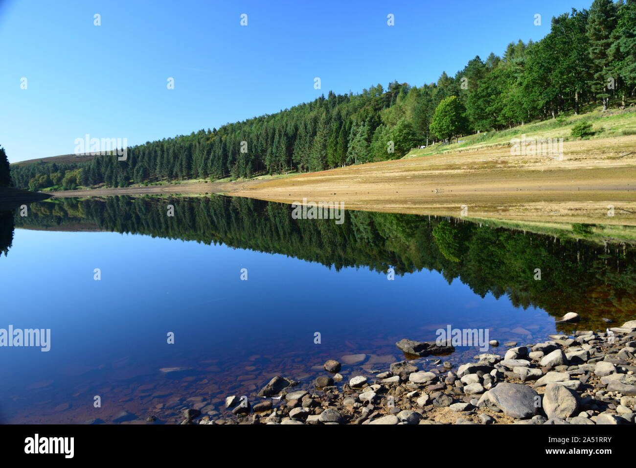 Réservoir Howden derbyshire angleterre, montrant le ciel et les rives reflétées dans l'eau encore en milieu d'été. Banque D'Images