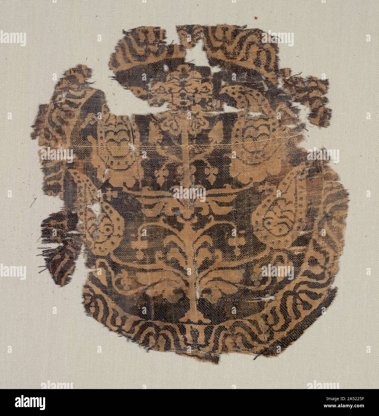 Cocarde avec palmettes curviligne, arbre d'une tunique, 600-850. A l'origine, ces chambres luxueuses, chacune avec des cocardes de la soie au moins trois pièces de correspondance, ont été coupés et cousus sur le devant et le dos d'une tunique, sans doute , en Egypte. Ils appartiennent à un groupe important de décorations soie comparables trouvés en Égypte, d'Akhmim. Dans chaque cercle, une palmette stylisée arbre est inclus dans une lotus simplifié, qui a été modifié à la frontière égyptienne antique motif lotus. Ces soies délicates ont été tissés sur métiers à grand motif de répétition automatique, appelé drawlooms. Bleu foncé et ivoire trames horizontales soie domi Banque D'Images
