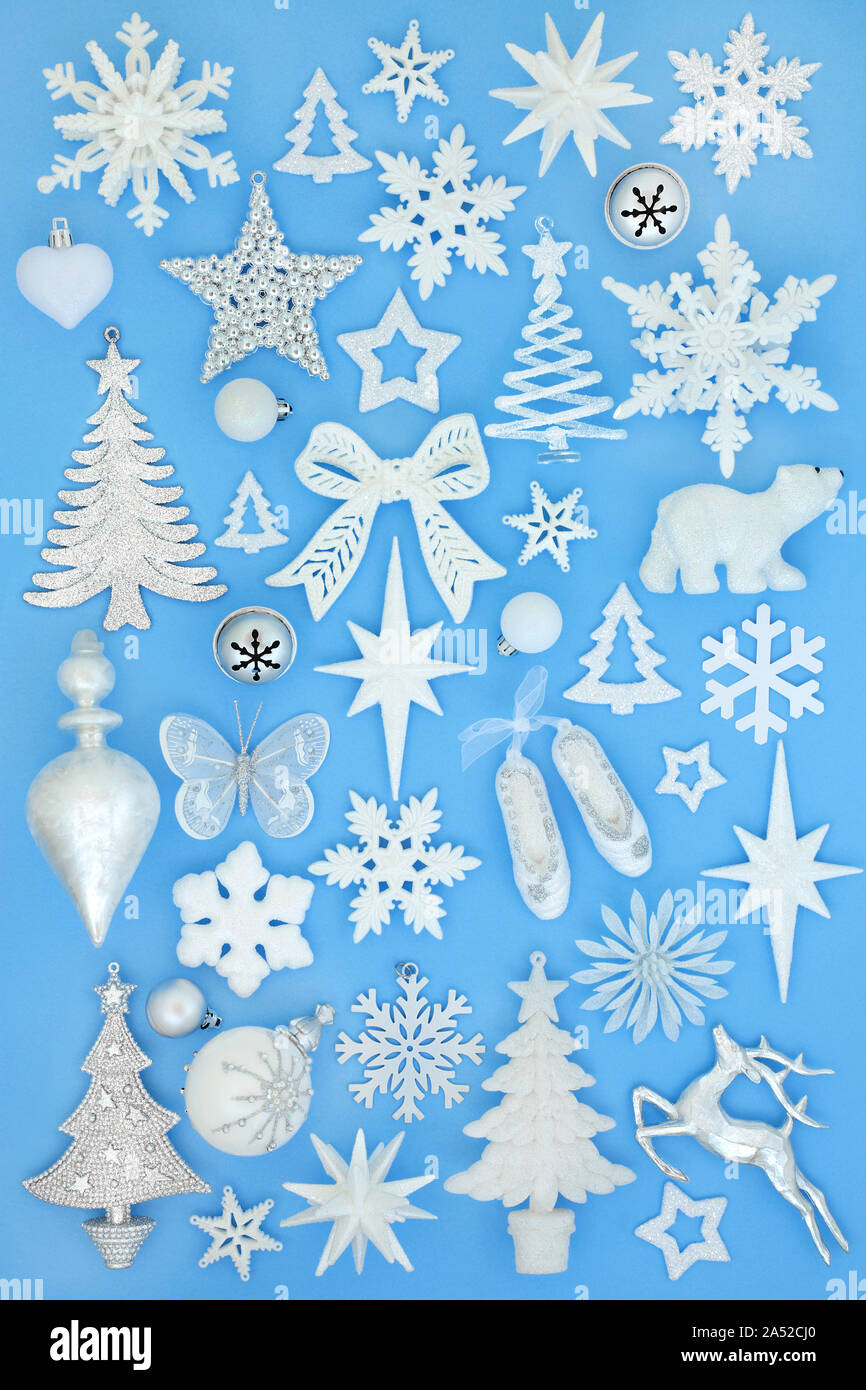 L'argent et l'arbre de Noël givré blanc décorations babiole et symboles sur fond bleu pastel. Symboles traditionnels pour les fêtes. Banque D'Images