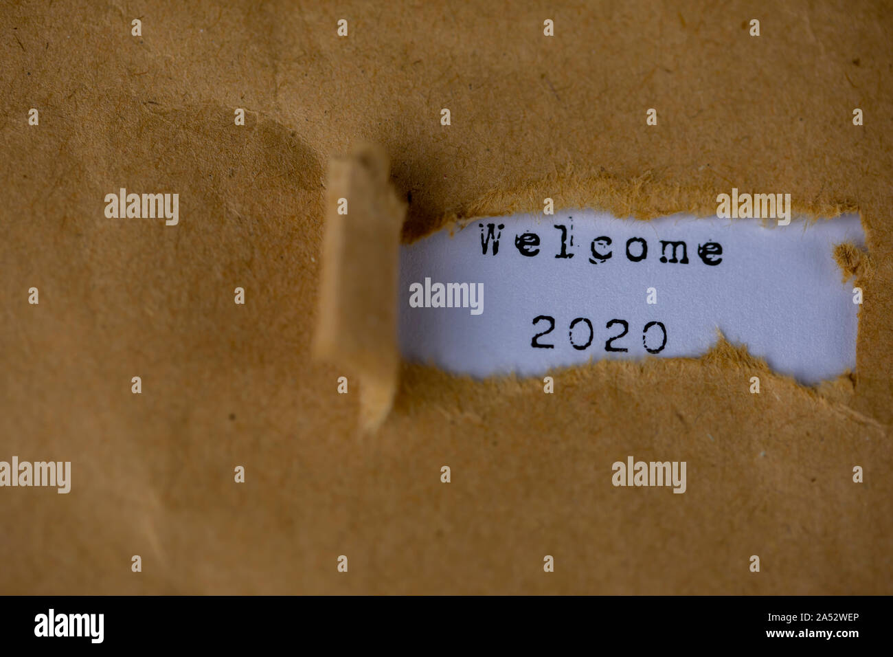 Le texte de bienvenue, 2020, apparaît derrière le papier marron déchiré Banque D'Images
