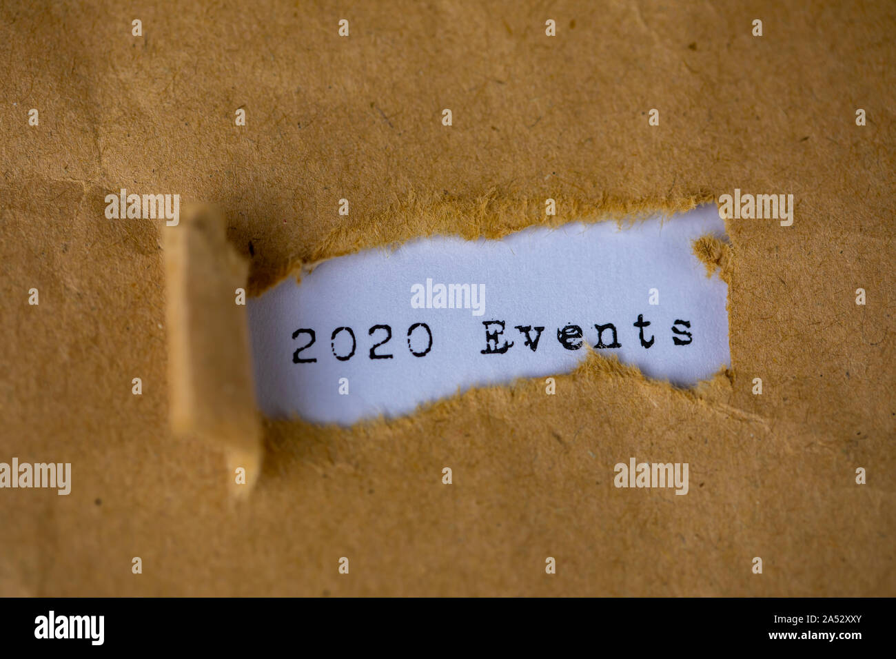 Le texte, 2020 événements, apparaît derrière le papier marron déchiré Banque D'Images