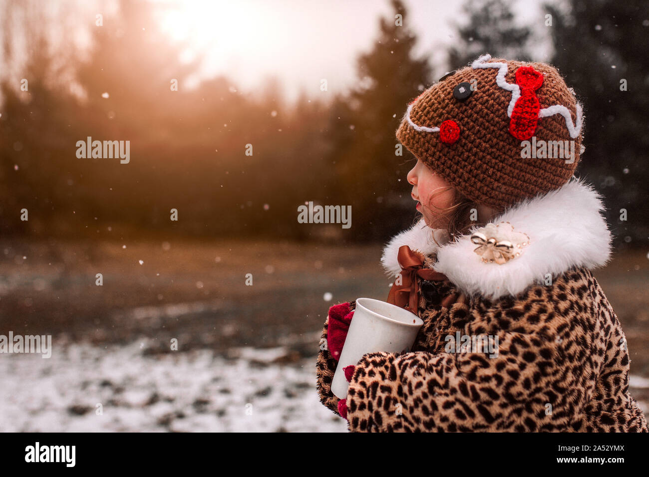 Petite fille livré par boire du chocolat chaud par une froide journée d'hiver Banque D'Images