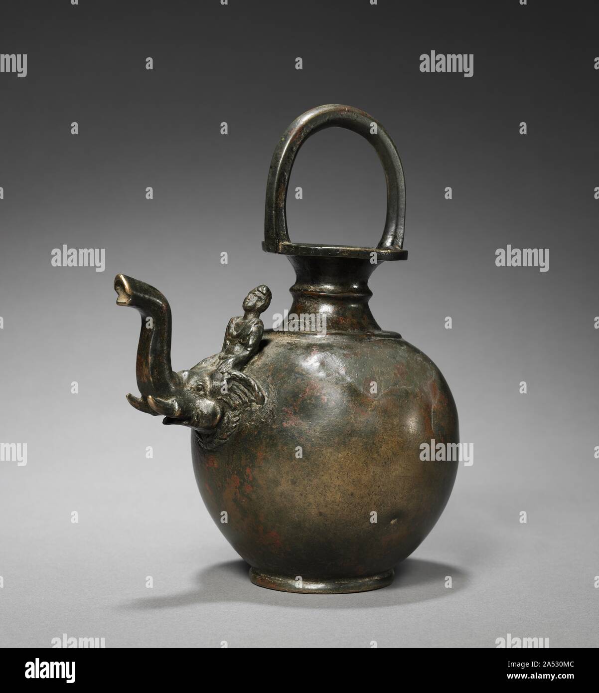 Ewer avec bec sous la forme d'un éléphant avec un Mahut, c. 1er siècle. Cette aiguière en forme de bulbe avec un pied bas, col étroit, et une poignée de boucle fixée sur le dessus du cou est moulé en une seule pièce. Le cou, avec un rebord en saillie qui s'élargit à l'embouchure, est décoré avec des moulures en bas et au centre. La poignée de boucle est octogonal en coupe. Plus intéressant est le déversoir dans la forme d'une tête d'éléphant avec un tronc et un mahout assis sur son cou. Le costume et turban porté par le cavalier sont Kusana, tandis que l'éléphant est indigène à la région. Navire semblable Banque D'Images