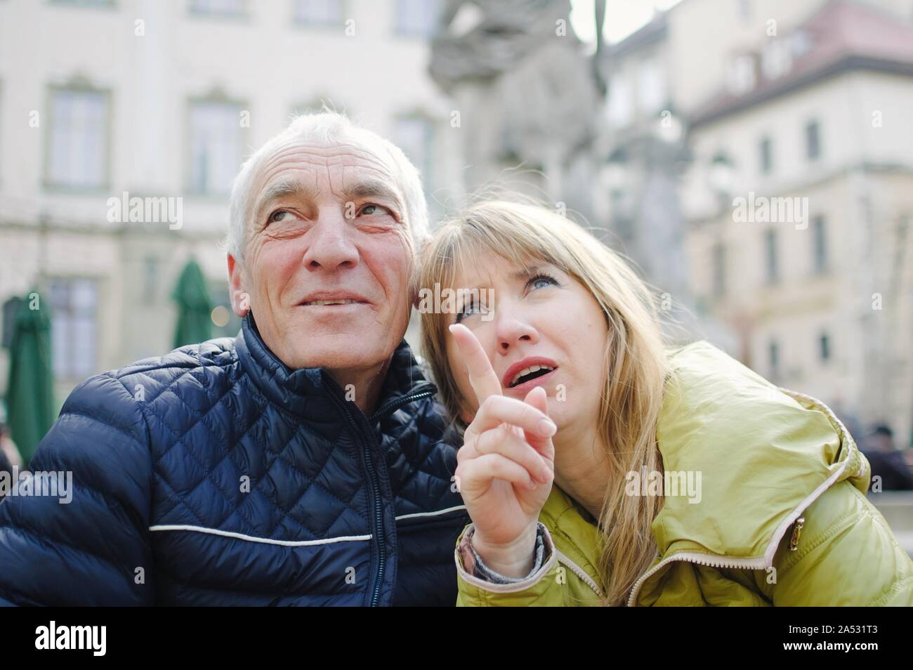 L'extérieur portrait d'un homme âgé et sa jeune femme blonde passer du temps ensemble dans l'ancienne cité au début du printemps ou en automne. Couple avec l'âge Banque D'Images