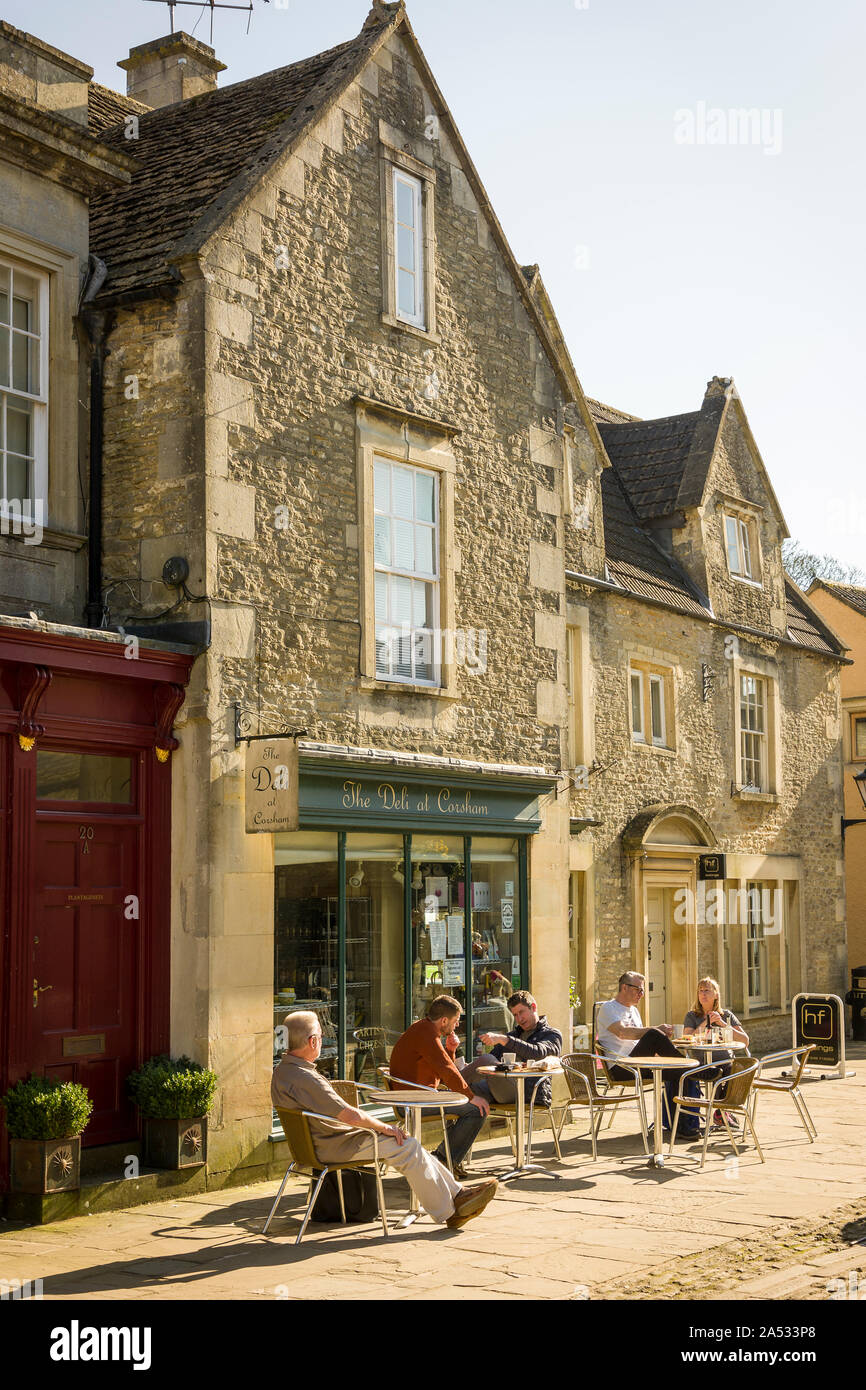 Assis à l'extérieur de l'épicerie à la fin de l'hiver soleil dans la grande rue Corsham Wiltshire England UK Banque D'Images