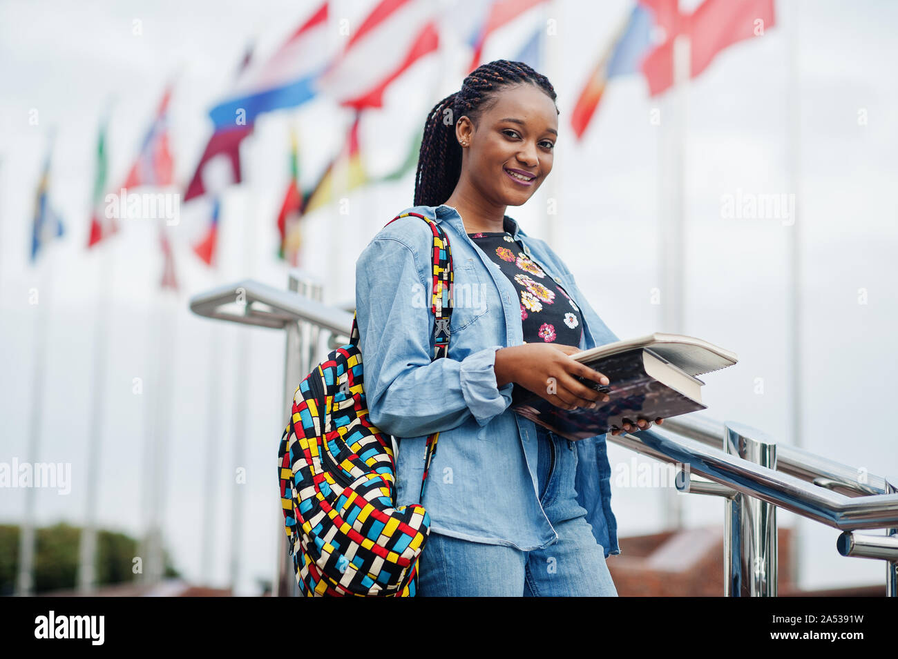 Étudiant africain femme posant avec sac à dos et sur les éléments de  l'école cour de l'université, les pavillons de différents pays Photo Stock  - Alamy