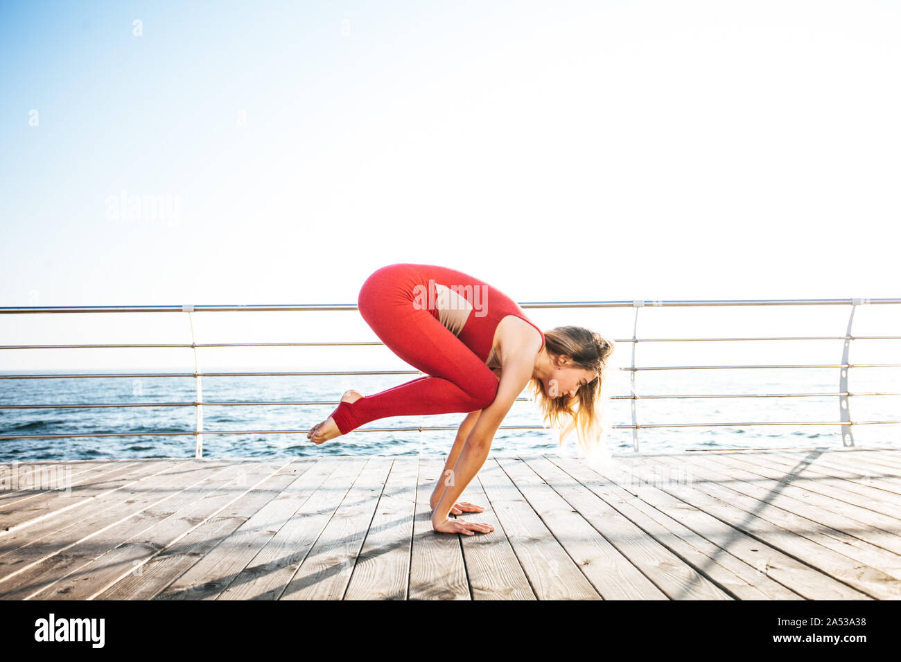 Belle femme pratiquant le yoga sur le bord de la mer à l'aube Banque D'Images