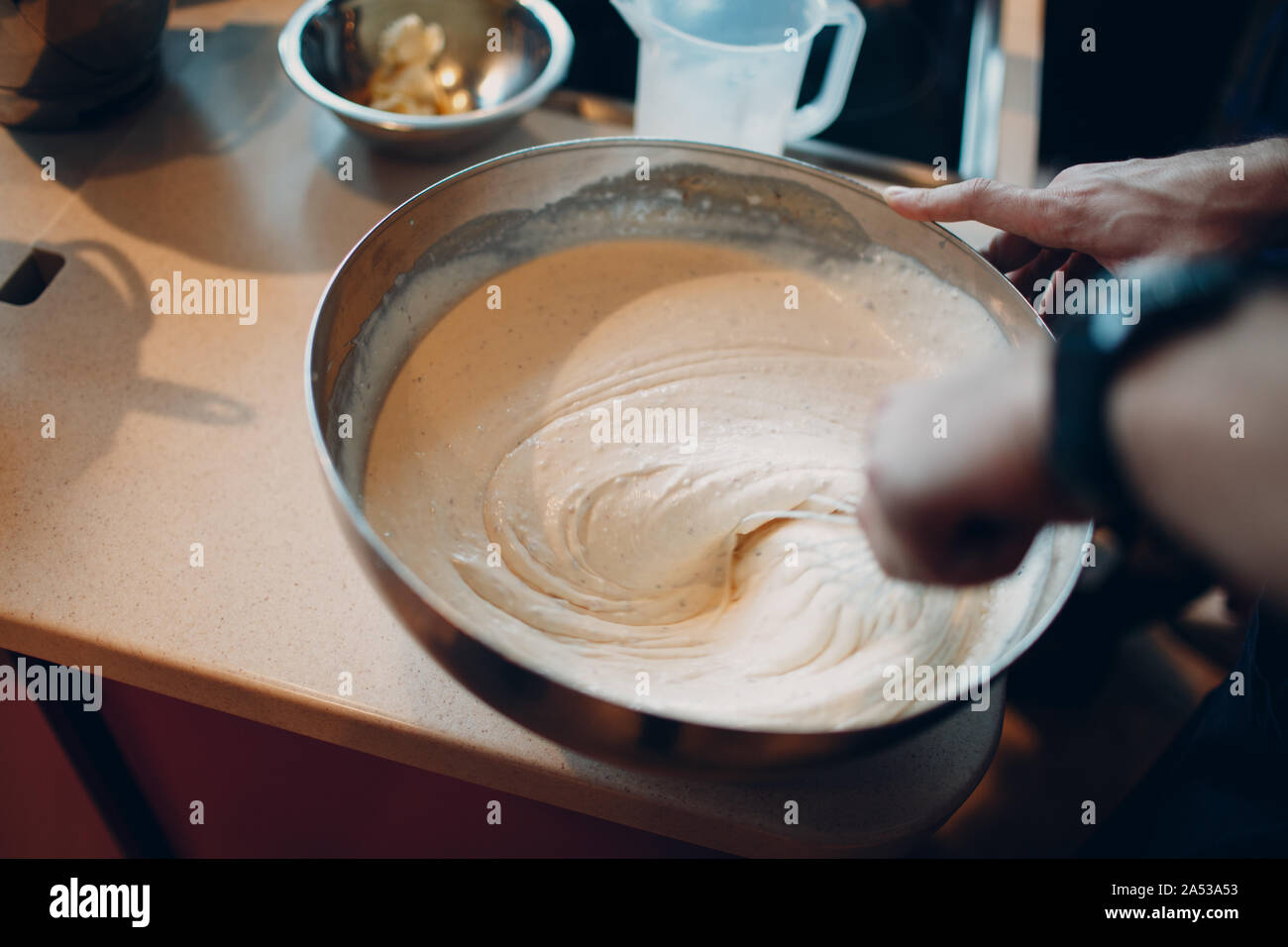 Remue la main blanche, pâte, sauce ou dessert dans un bol Banque D'Images