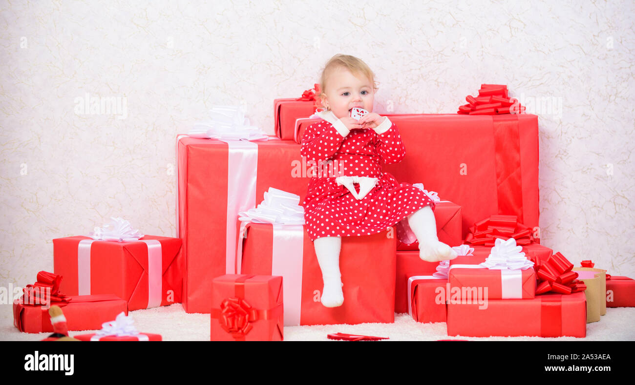 Little baby girl jouer près de tas de boîtes cadeaux. Cadeaux pour enfant premier noël. Première fête de Noël. Des cadeaux de Noël pour tout-petit. Premier Noël de bébé, au cours de la vie, une fois l'événement. Vacances en famille. Banque D'Images