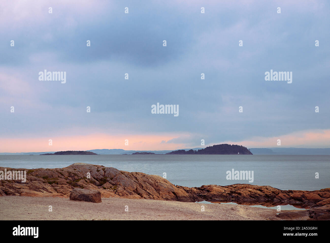 Le Fjord d'Oslo paysage avec de petites îles, l'eau calme, ciel couvert. Les roches d'Orange sur la plage, la tranquillité. Nesodden la Norvège. Côte norvégienne péninsule. Banque D'Images