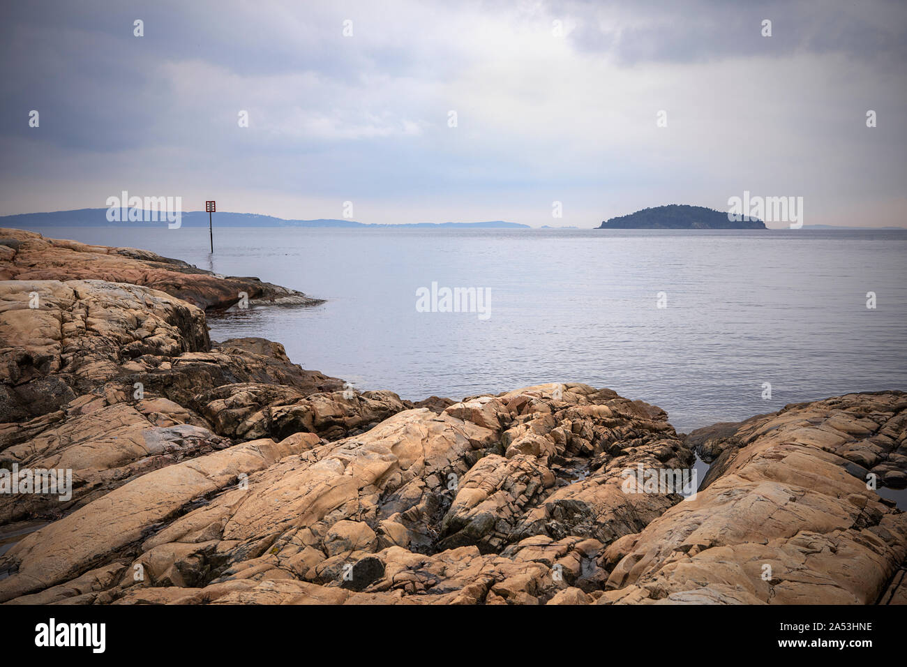 Vue sur le fjord d'Oslo, l'eau calme, visibles de l'île. Paysage avec des rochers sur la plage. Côte norvégienne en été. Nesodden la Norvège. Nesoddtangen péninsule. Banque D'Images