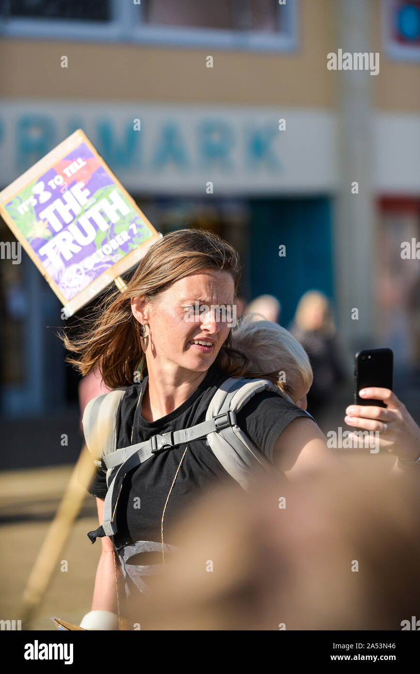 Un manifestant une prise avec son smartphone selfies comme elle participe à l'Extinction du climat de rébellion en grève Truro Ville Ville de Cornwall. Banque D'Images