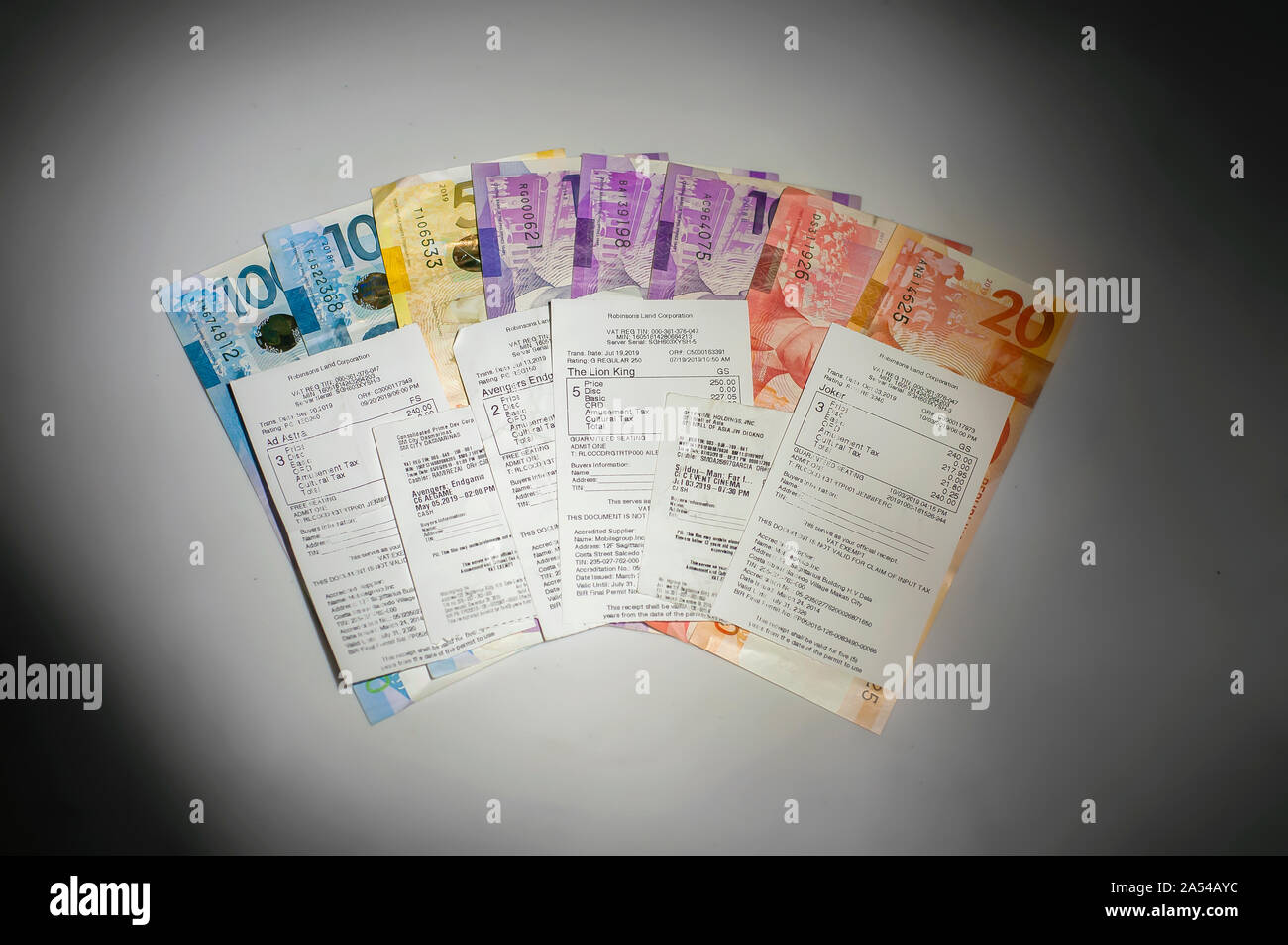 Divers admettre un billets de cinéma de célèbres blockbusters de 2019. Billets de cinéma placé au sommet de Philippine peso bills. Monnaie peso philippin Banque D'Images