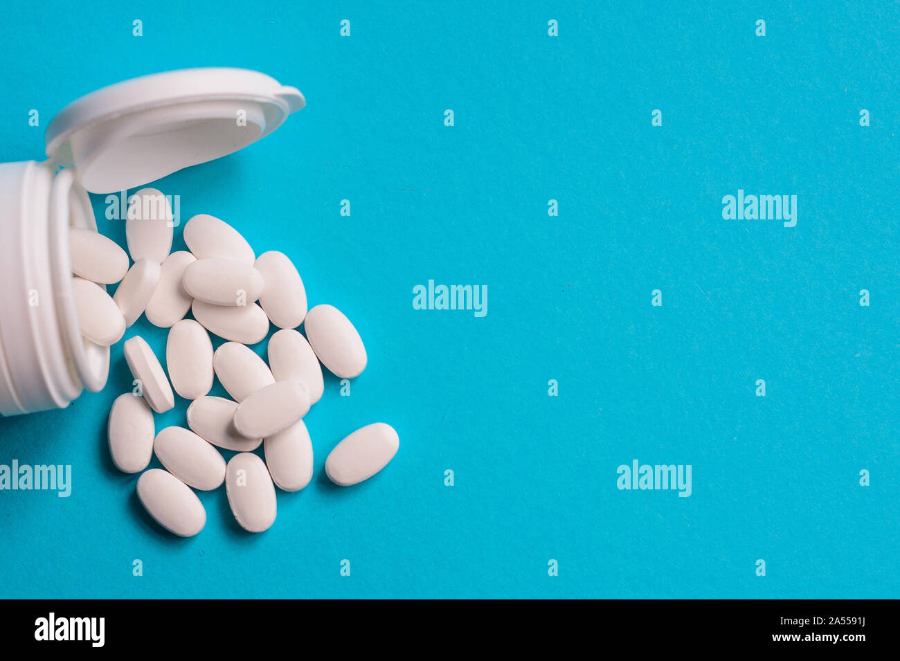 Pilules médical blanc sur fond bleu représentant le concept de soins de santé Banque D'Images