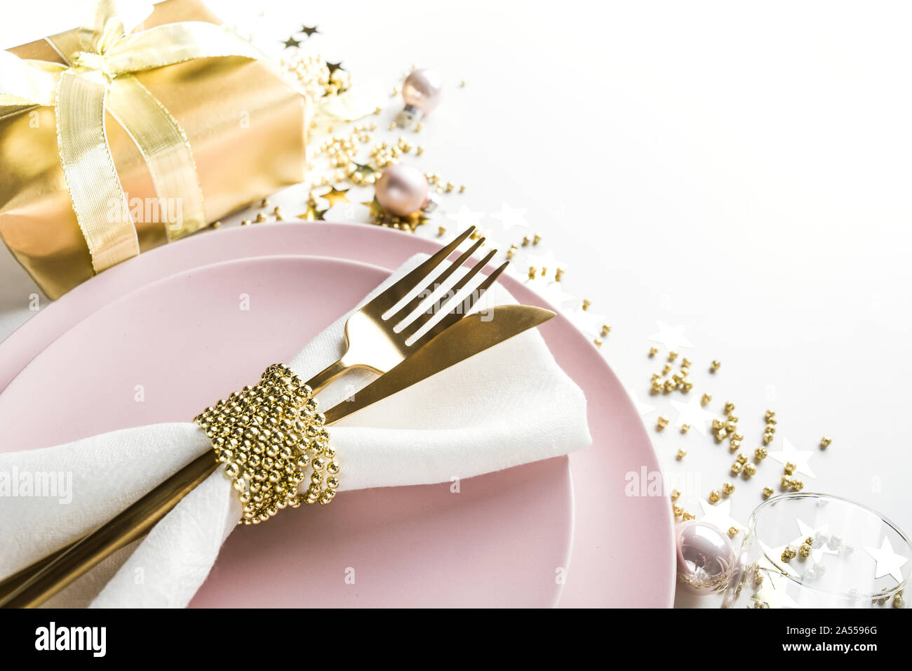 L'élégance de Noël table avec vaisselle, couverts d'or rose sur fond blanc. Vue d'en haut. Le dîner de Noël. Banque D'Images