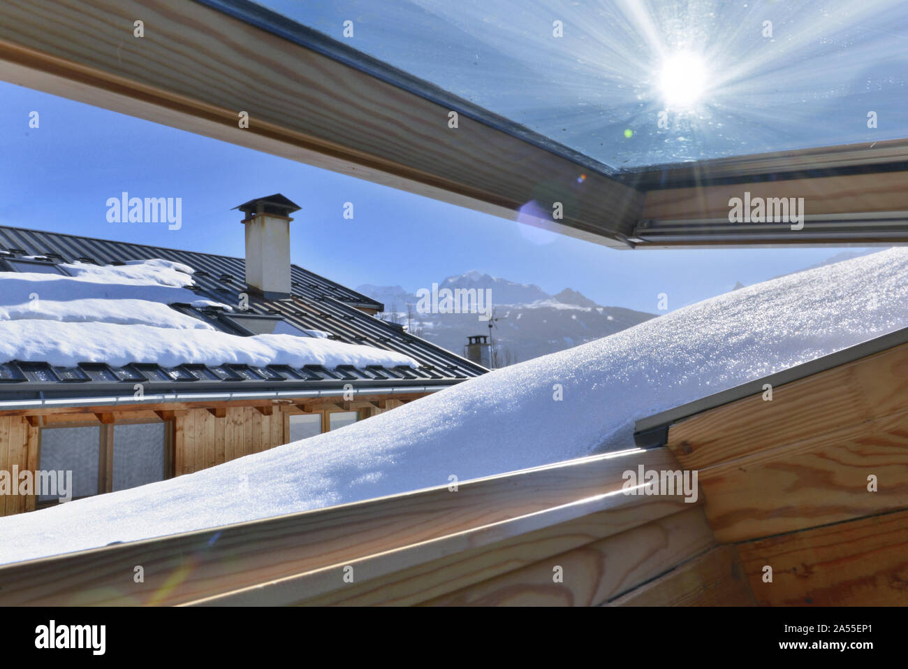 Vue depuis une fenêtre ouvrant sur un revêtement de toiture avec de la neige dans un chalet alpin Banque D'Images