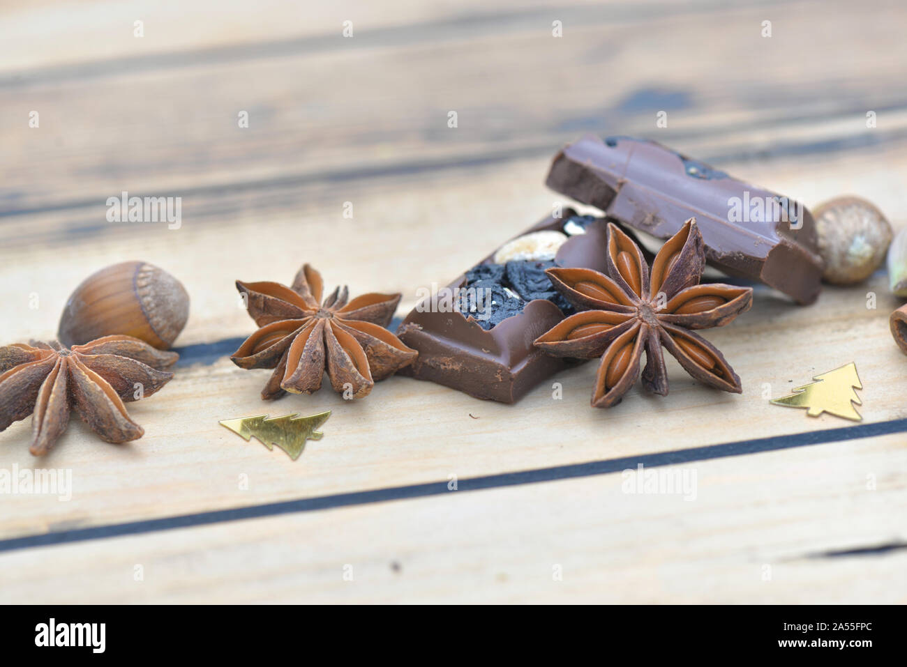 Libre d'épices et au chocolat avec des noix et des confettis de noël sur une table en bois Banque D'Images