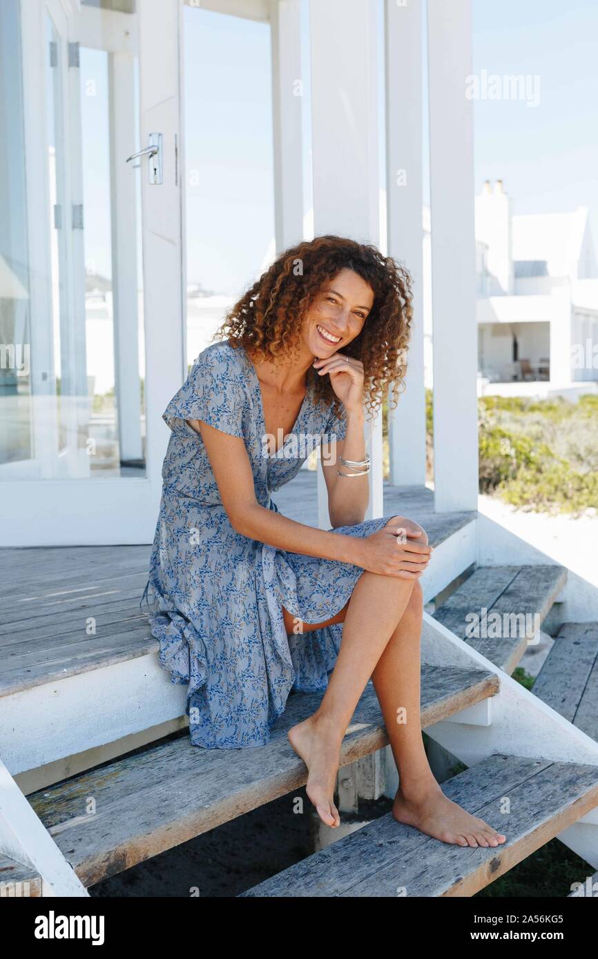 Woman relaxing on marches de beach house Banque D'Images