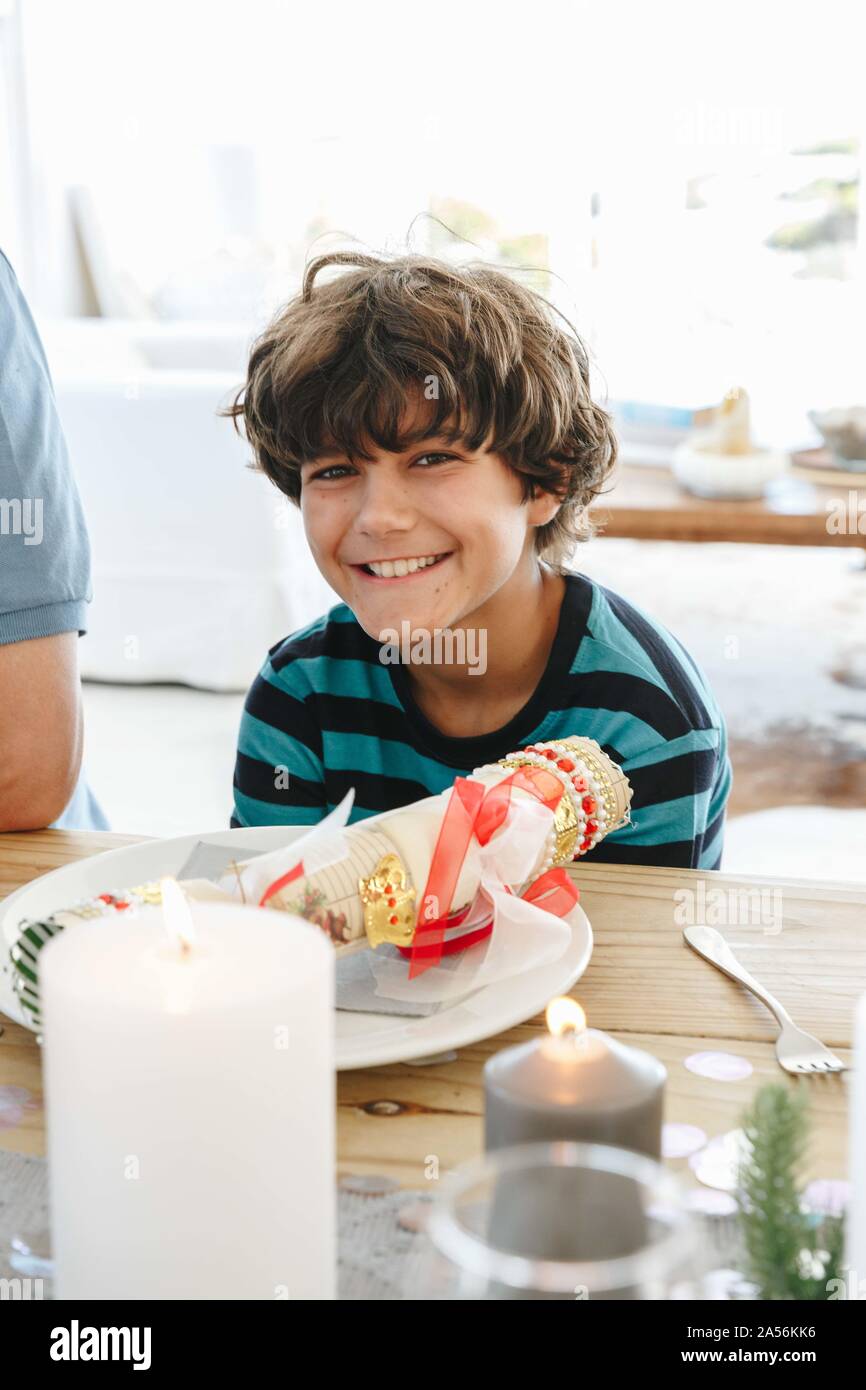 Boy smiling at table à manger en home party Banque D'Images