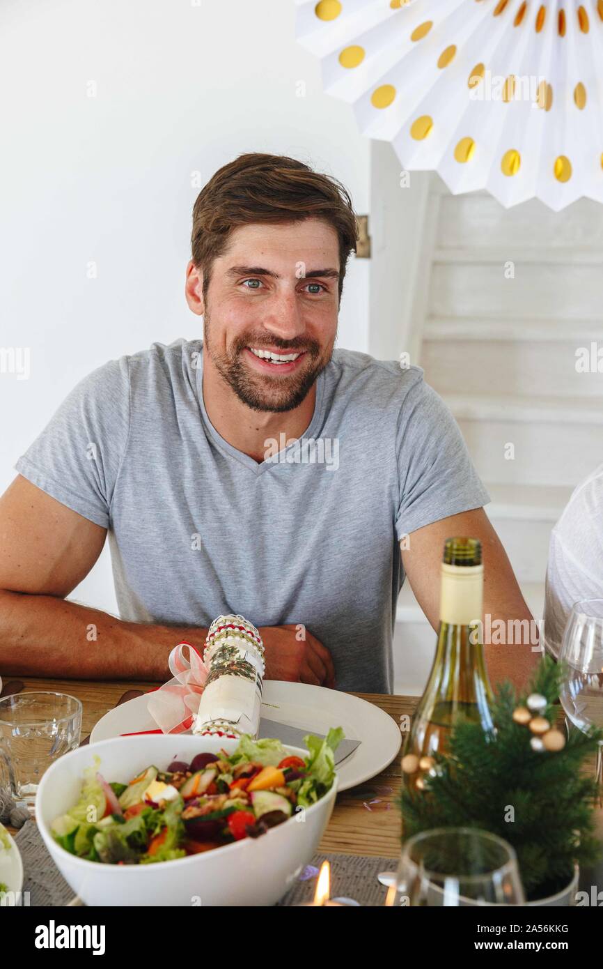 L'homme écoute sur table à manger en home party Banque D'Images