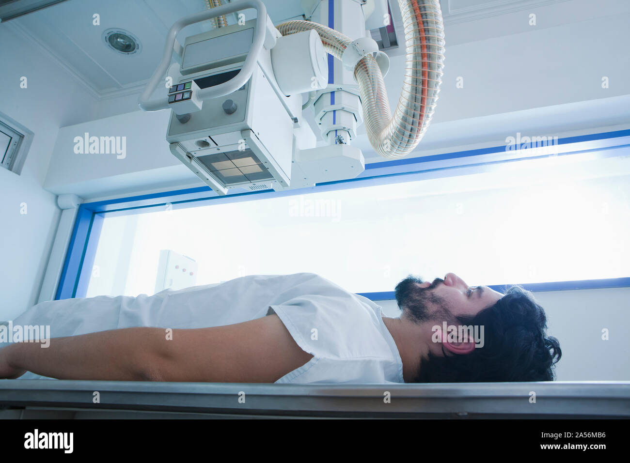 Young male patient ayant un CT scan en radiologie, side view Banque D'Images
