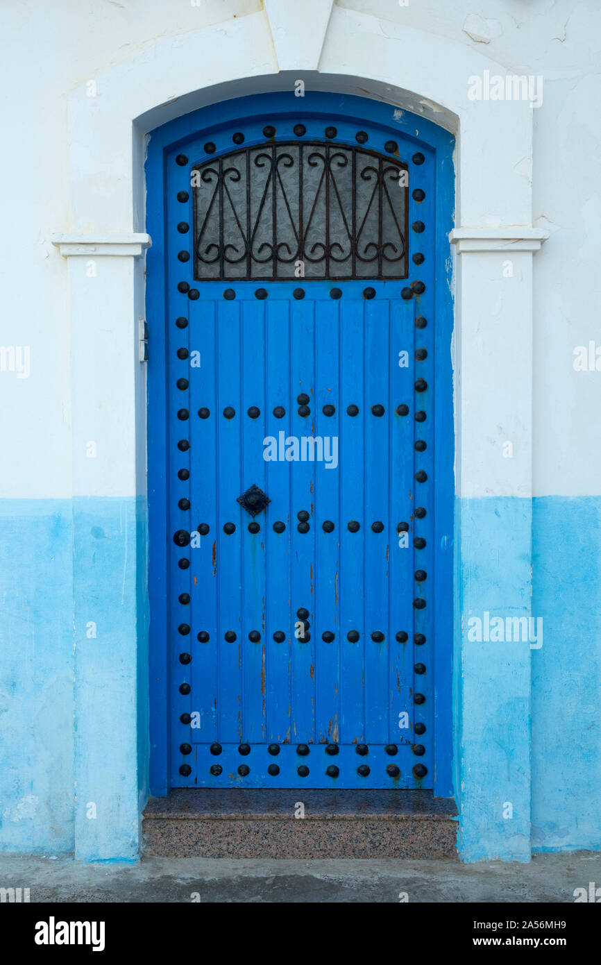 Porte en bois peint en bleu avec décoration en noir dans la médina d'Asilah, Maroc Banque D'Images