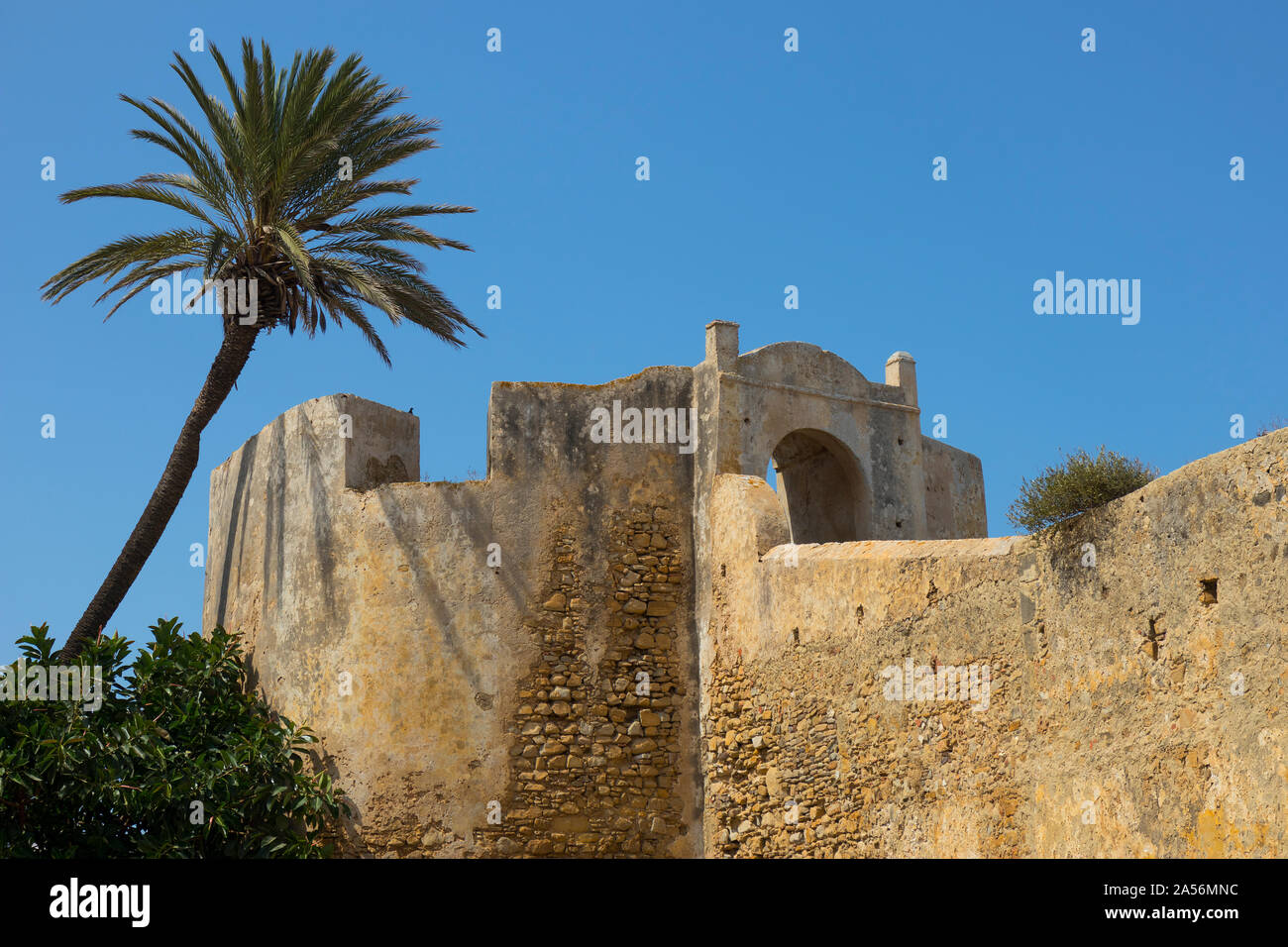 L'extérieur de l'ancien mur de fortification en pierre et la porte d'Asilah, Maroc avec un ciel bleu Banque D'Images