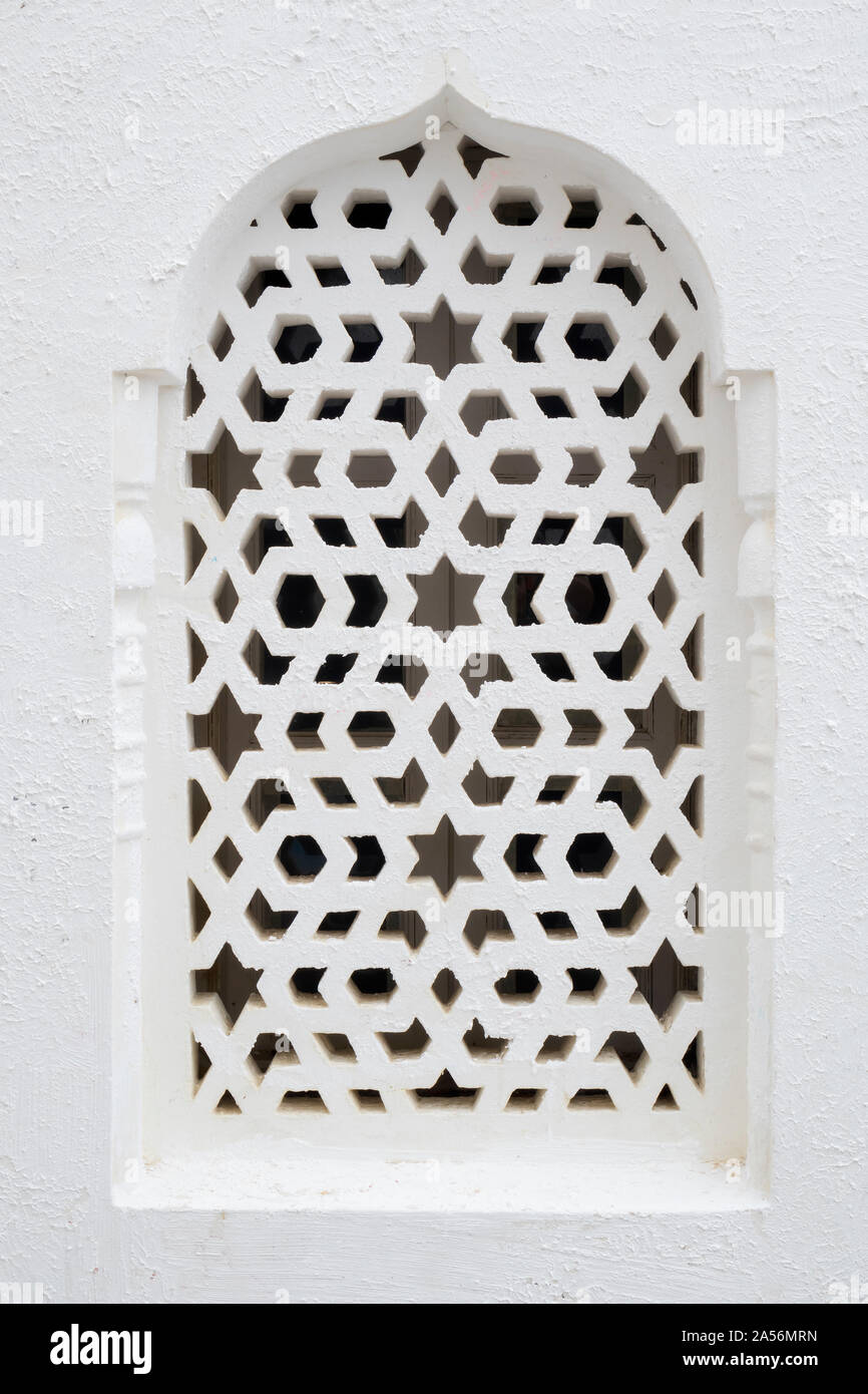 Fenêtre blanc marocain traditionnel protégé par un obturateur de conception à Asilah, Maroc Banque D'Images