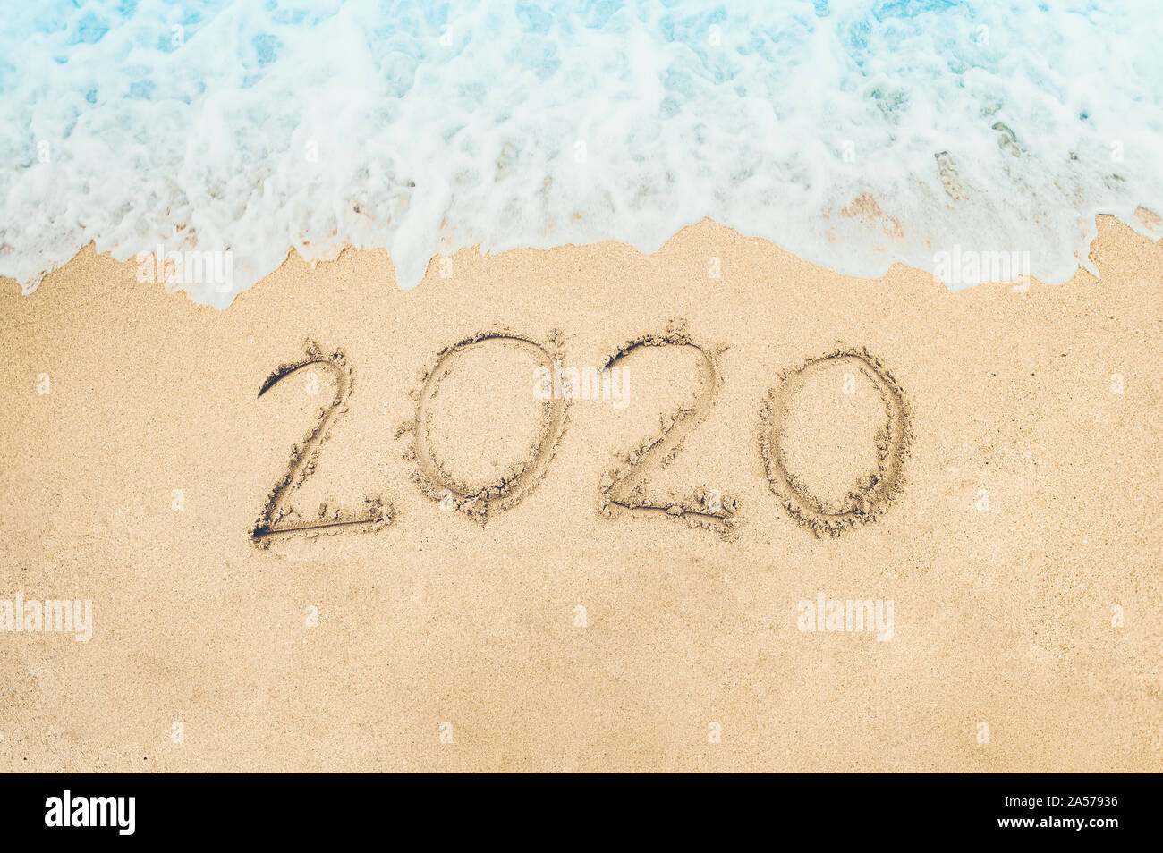 Bonne Année 2020 écrit sur le sable de mer au lever du soleil concept.belle plage de sable et des vagues de l'océan bleu Banque D'Images