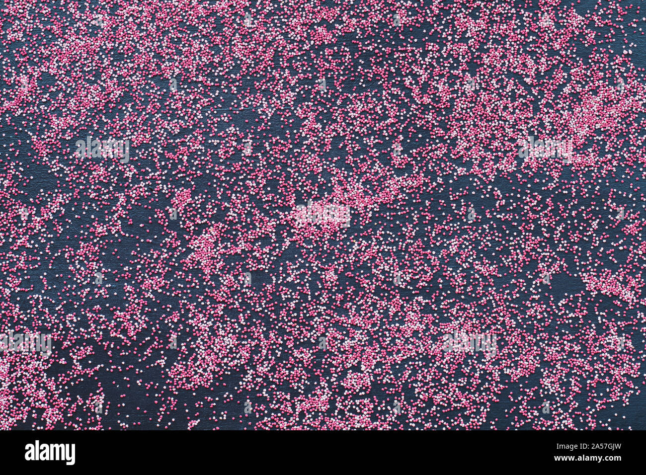 Résumé Vue d'en haut de la dispersion des graines de trèfle inoculé rose sur fond noir. Banque D'Images