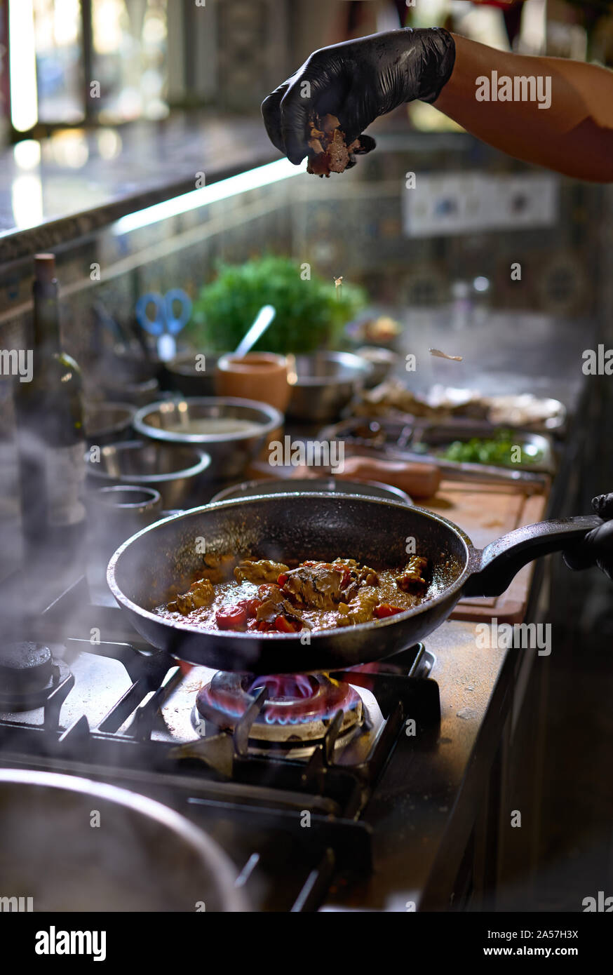 Concept alimentaire. Le chef ajoute truffle fry dans une casserole les tomates et les huîtres. Le processus de cuisson de spaghettis aux fruits de mer. Banque D'Images