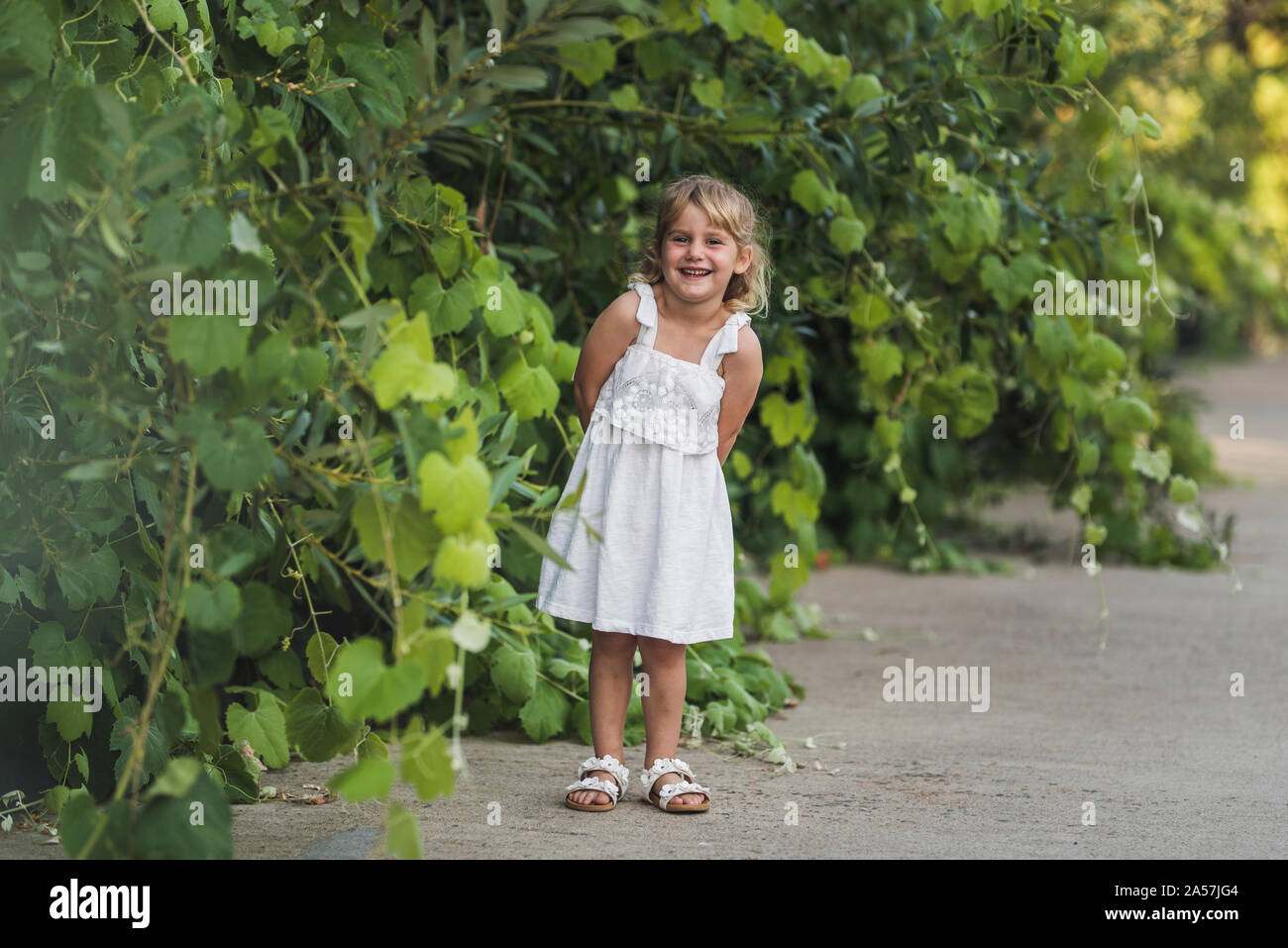 Sweet smiling girl wearing sundress avec un fond d'un écrin de verdure Banque D'Images