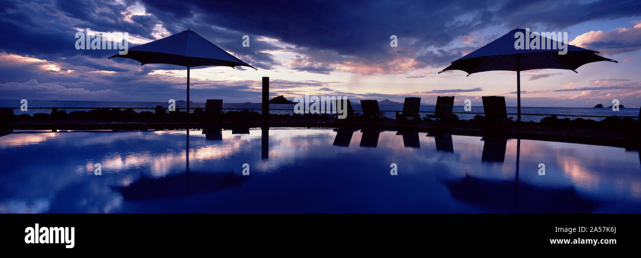 Piscine du complexe au coucher du soleil, Brampton Island Resort, Brampton Island, Whitsunday Islands, Queensland, Australie Banque D'Images