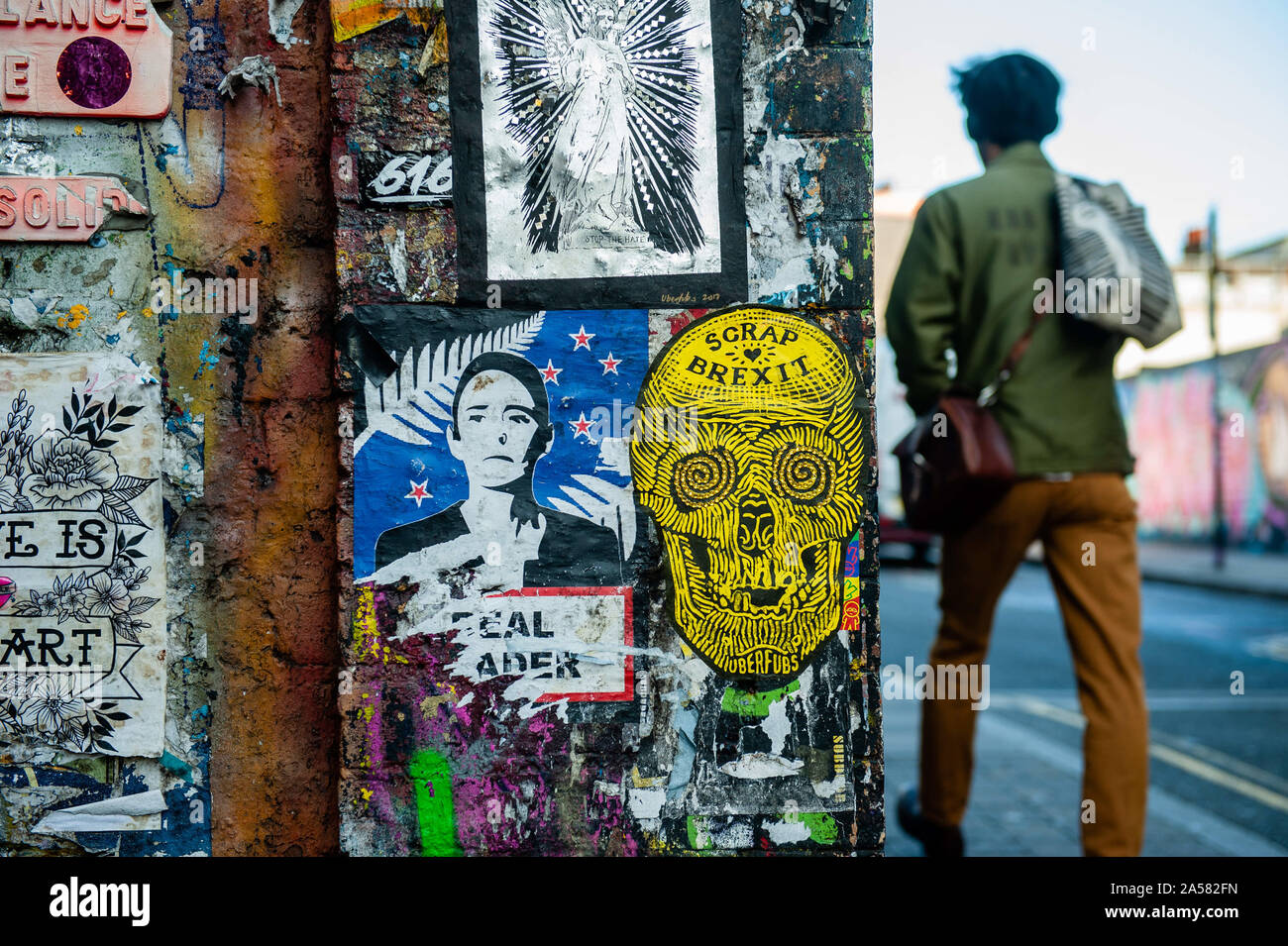 Londres, Royaume-Uni. 18 Oct, 2019. Un homme marche près d'un mur avec Anti Brexit art sur elle.La date limite à l'horizon, Brexit les peintures murales et collez-bonus apparaissent sur les rues de Londres. Brick Lane, dans l'East End londonien, est un des endroits les plus populaires pour trouver toutes sortes d'art autour du Brexit. Aussi dans le célèbre quartier de Shoreditch, les touristes à pied et prendre des photos autour de cet art de rue politique Crédit : Ana Fernandez/SOPA Images/ZUMA/Alamy Fil Live News Banque D'Images