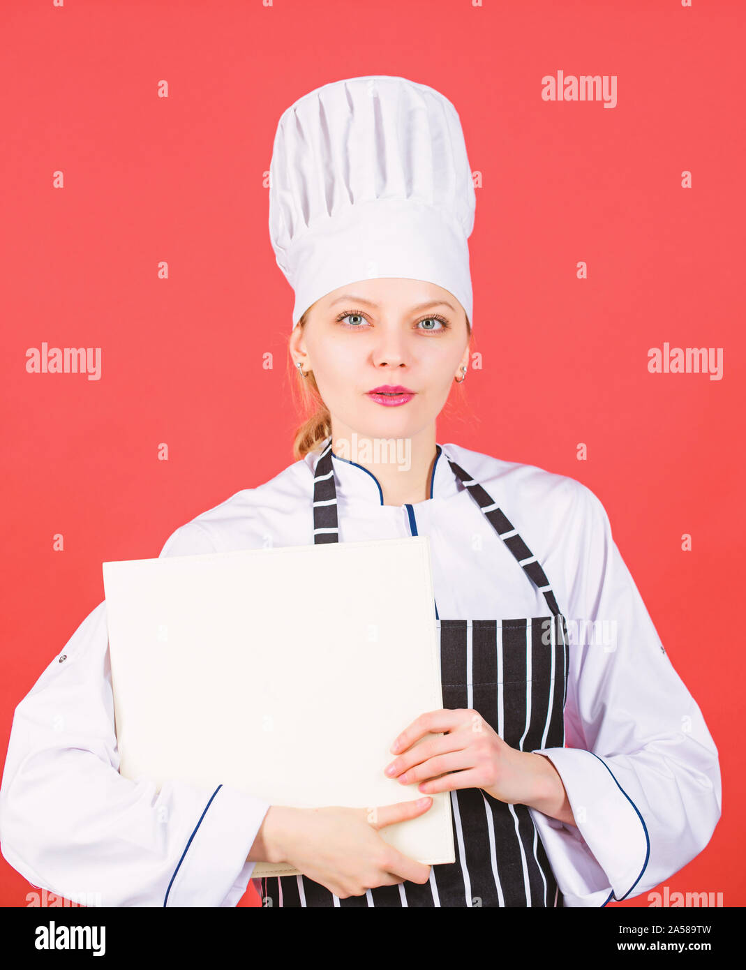 Femme au foyer avec livre de cuisine. menu du restaurant. Suivre un régime culinaire. Femme au chapeau et un tablier cook. chef professionnel en cuisine. Cuisine. woman cooking alimentation saine par recette. Beautés Sweetie. Banque D'Images