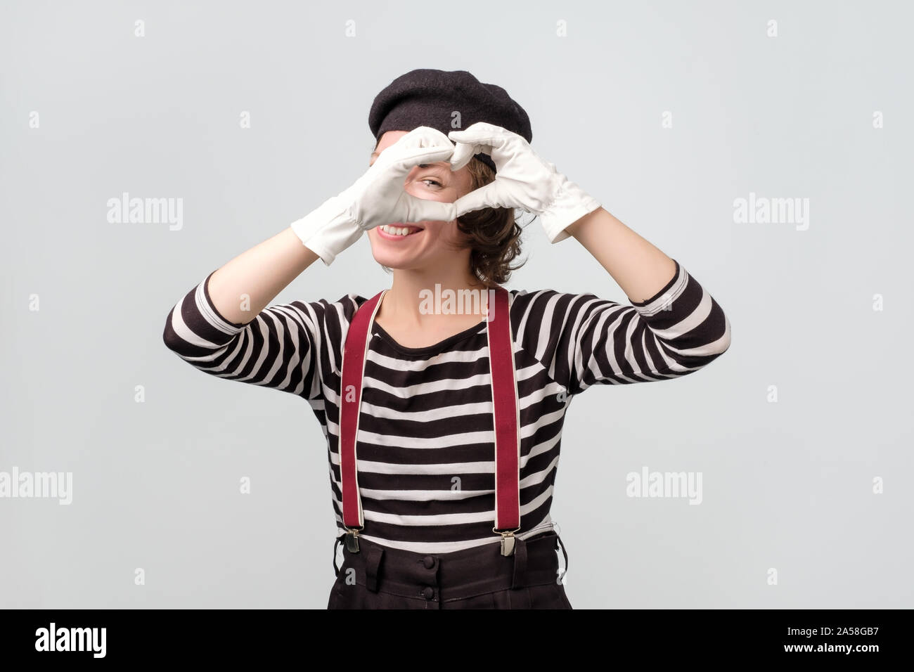 Jeune femme habillée comme une forme de cœur mime signe avec ses mains Banque D'Images