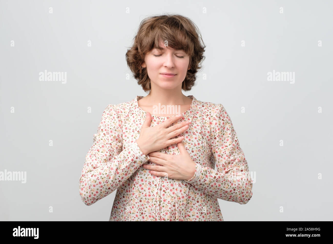 Jeune femme avec ses yeux fermés ayant des pensées positives Banque D'Images