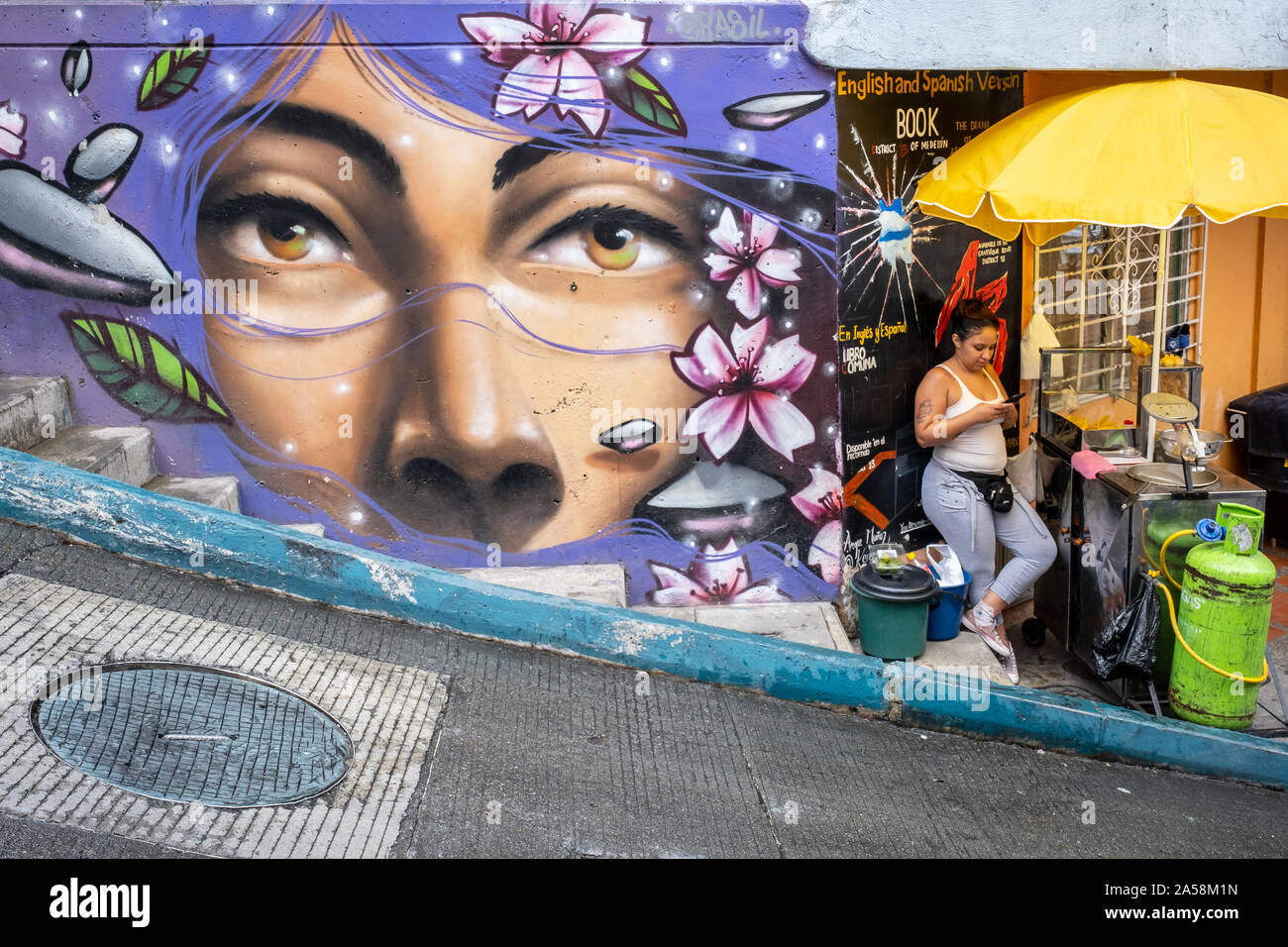 Femme, Street food stand et art de rue, graffiti, fresque, Comuna 13, Medellín, Colombie Banque D'Images