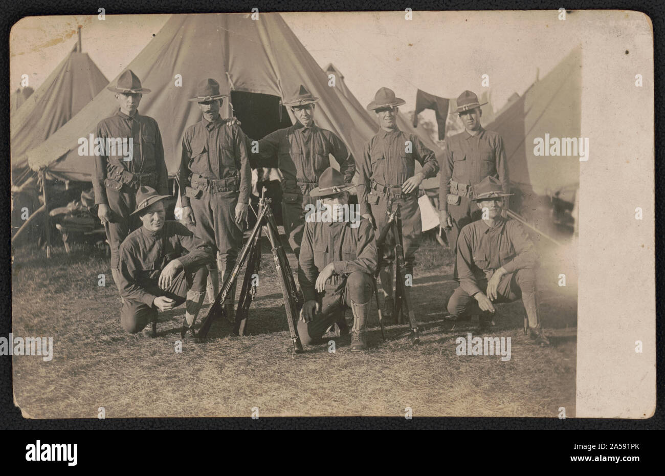 Soldats non identifiés en uniforme avec des fusils en face de tentes Banque D'Images
