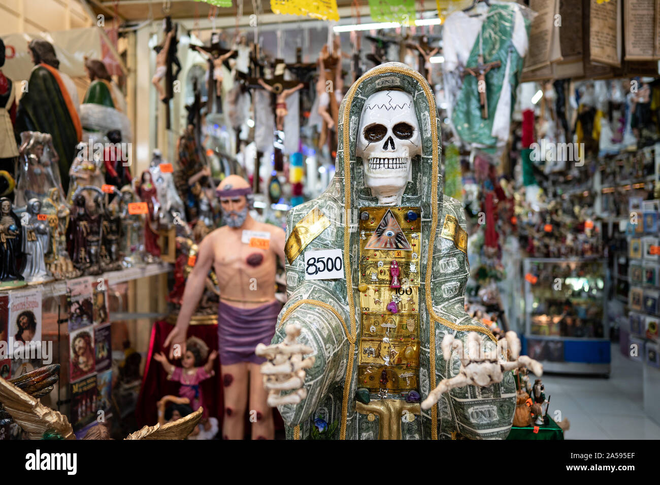 Un squelette est vu avec figurines religieuses dans un magasin à la Merced marqués dans le centre de Mexico. Banque D'Images