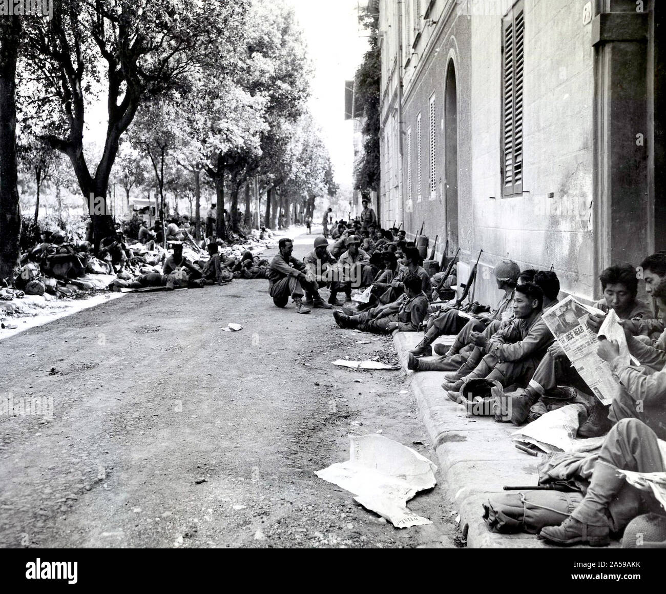 Les Américains d'origine japonaise du 100e Bataillon d'infanterie, reste dans une rue de Livourne, Italie, après une épuisante, l'avance de l'Armée de cinquante qui a pris fin avec la chute de cet important port maritime. Juillet 19, 1944 Banque D'Images