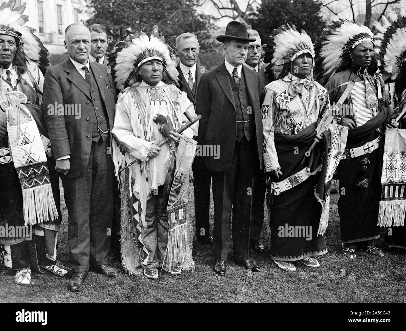 Le président Calvin Coolidge avec les Indiens en tête des robes et des vêtements traditionnels ca au début des années 1900. Banque D'Images