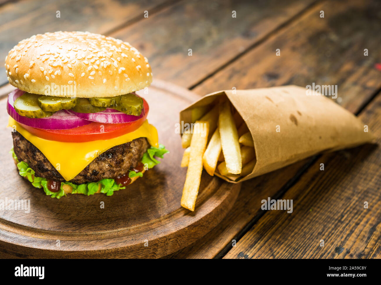 Cheese burger et frites contre fond de bois. De savoureux repas rapides. Banque D'Images