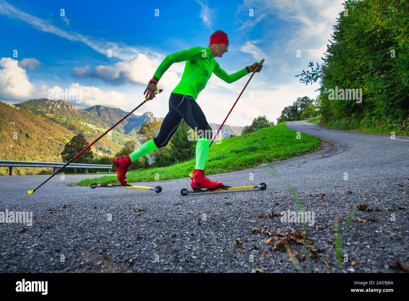 Un athlète, à la formation de patins à roulettes. Simule le ski nordique Banque D'Images