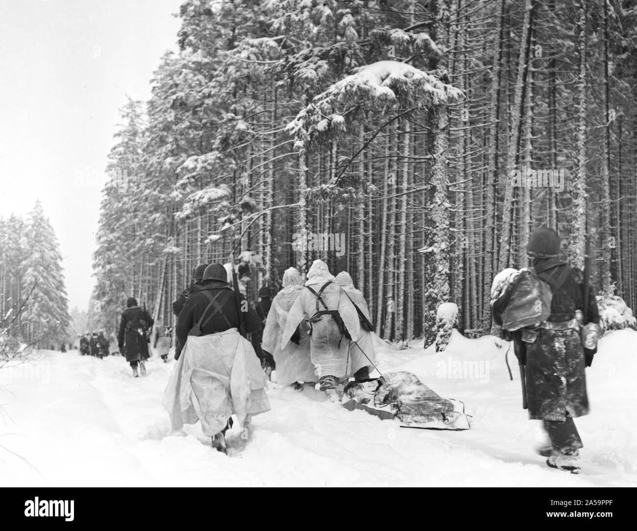 Légende originale : les troupes américaines faites glisser un traîneau lourdement chargé de munitions à travers la neige, qu'ils se déplacent d'une attaque à Herresbach, Belgique. 1/28/45. 1er Bn., Co. C., 325e Glider Reg't., 82e A/B Div. Banque D'Images