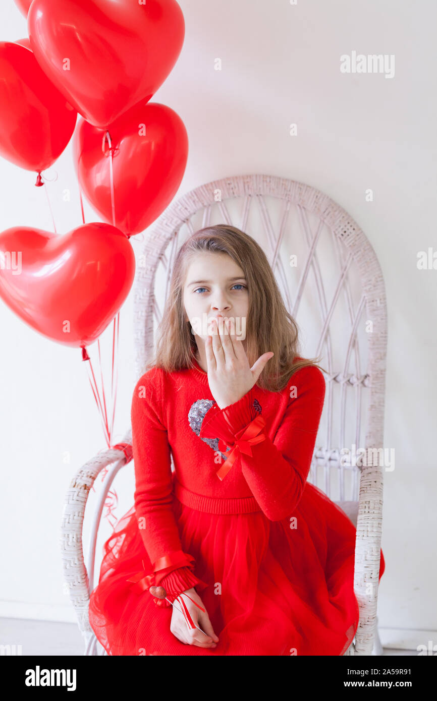 Petite fille avec ballons rouges le jour de la Saint-Valentin Banque D'Images