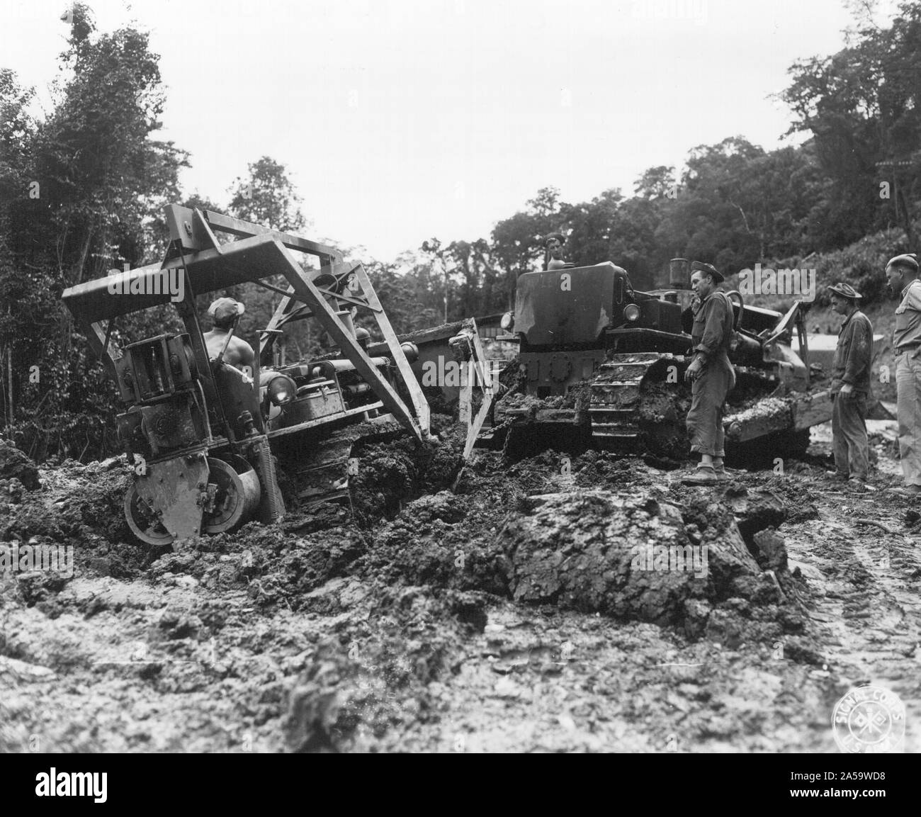 Un Caterpillar D-8 D-4 d'un petit tirant hors de la boue au Mile 52 le long de la route de Ledo pendant des travaux de maintenance 24/06/1944 Banque D'Images