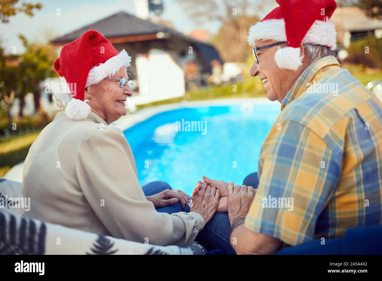 Hauts smiling couple in Santa hats celebrating Christmas Banque D'Images