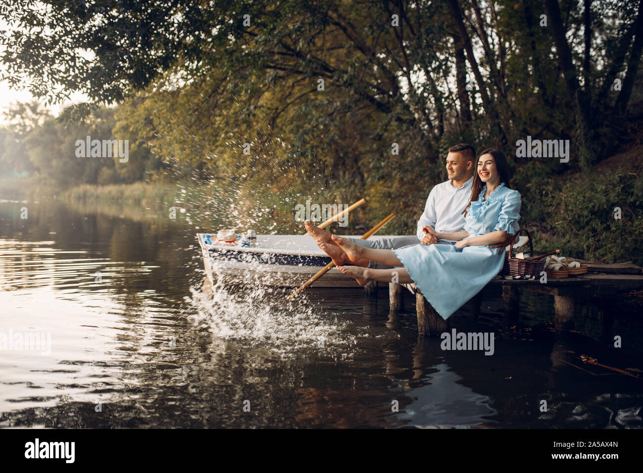 Love couple assis sur la jetée sur le lac tranquille Banque D'Images