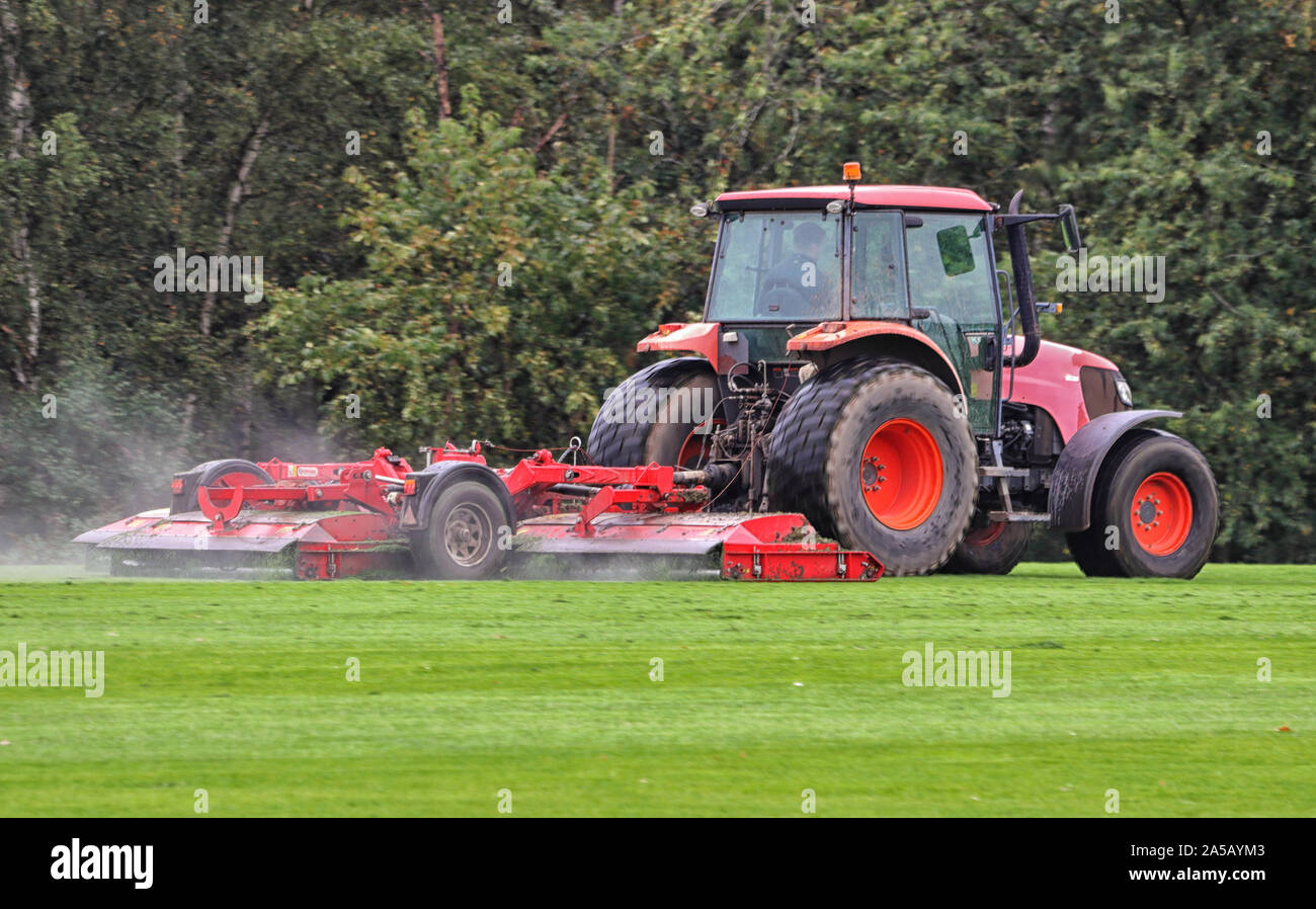 Tracteur avec remorque de la tonte de l'herbe avec pulvérisation d'eau dans l'air Banque D'Images
